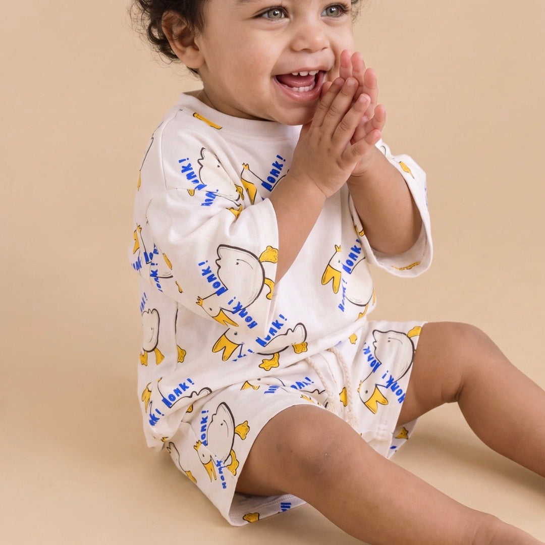 Child seated in the Nik and DELLE Honk Honk goose oversized cotton shirt and shorts set