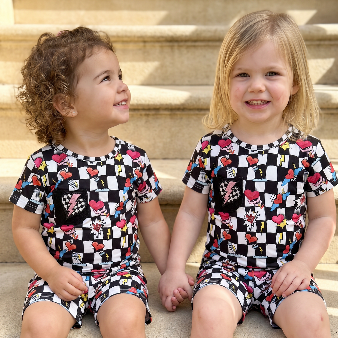 two toddler sitting in their checkers bamboo pajamas