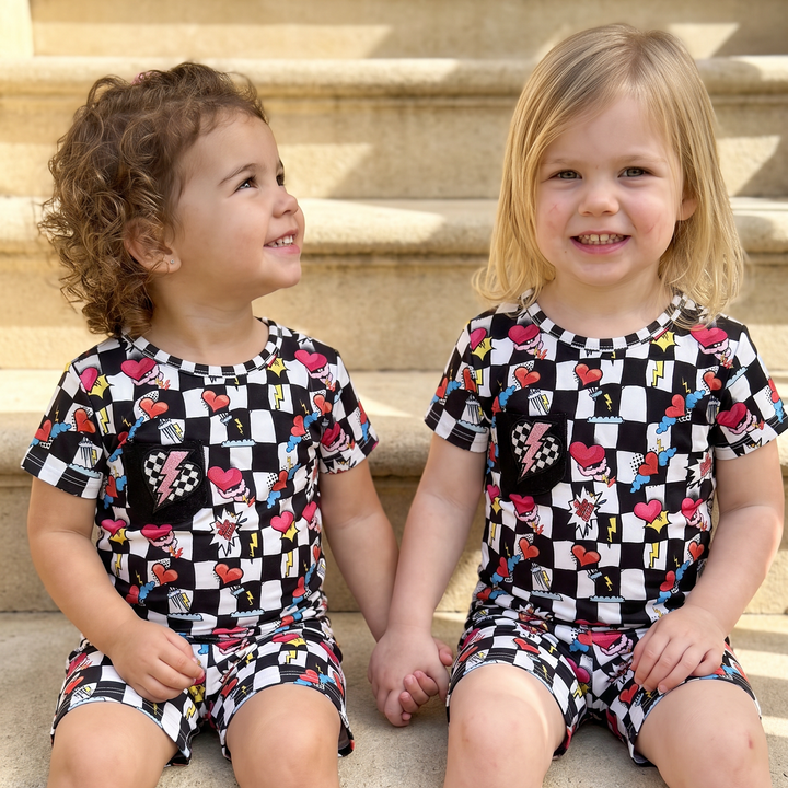two toddler sitting in their checkers bamboo pajamas